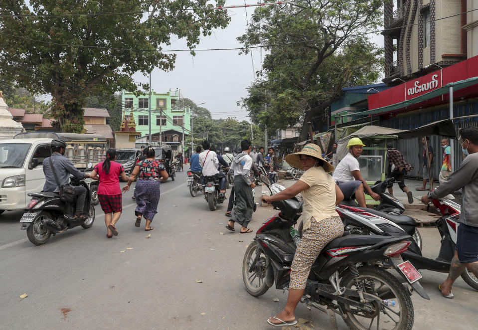 People scatter as a convoy of soldiers and police arrive to clear barricades made by anti-coup protesters in Mandalay, Myanmar, Thursday, March 11, 2021. The U.N. Security Council unanimously called for a reversal of the military coup in Myanmar on Wednesday, strongly condemning the violence against peaceful protesters and calling for “utmost restraint” by the military. (AP Photo)