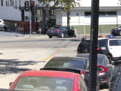 <p>Police officers stand guard near a crashed vehicle outside a Trader Joe’s store in the Silver Lake neighborhood of Los Angeles on Saturday. Police believe a man involved in the standoff with officers shot his grandmother and girlfriend before firing at officers during a pursuit, then crashing outside the supermarket and running inside the store. (Photo: Christian Dunlop via AP) </p>