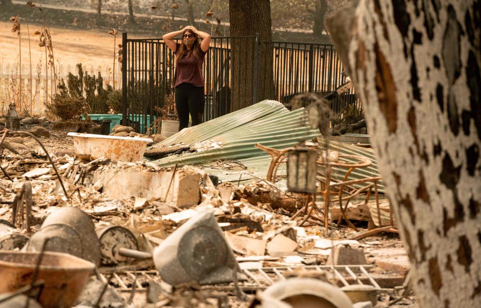 Alyssa Medina looks over the charred remains of her family home during the LNU Lightning Complex Fire in Vacaville, Calif., on Aug. 23.