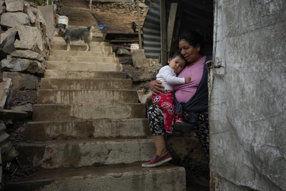 Justina Flores holds her grandchild Maria Paz while resting in the entrance of her home in the Pamplona Alta area in Lima, Peru, Friday, March 8, 2024. Peru’s government gives potable water to 1.5 million of its poorest residents, like Flores, living in the hills. (AP Photo/Martin Mejia)