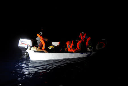 Migrants are seen on board a fiberglass boat in the Mediterranean Sea, off the Libyan Coast, August 12, 2018. REUTERS/Guglielmo Mangiapane
