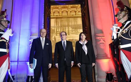 Paris mayor Anne Hidalgo (R) and French Foreign Minister Laurent Fabius (L) greet French President Francois Hollande upon his arrival for a meeting on the climate with European mayors ahead of the COP21 climate change summit at Paris city hall March 26, 2015. REUTERS/Eric Feferberg/Pool