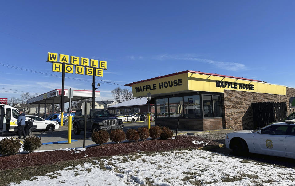 Police cars are shown near a Waffle House in Indianapolis Monday, Feb. 19, 2024, where at least one person was killed and several injured. (AP Photo/Isabella Volmert)