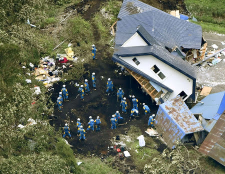 Police officers search for survivors from a house damaged by a landslide caused by an earthquake in Atsuma town, Hokkaido, northern Japan. Kyodo/via REUTERS