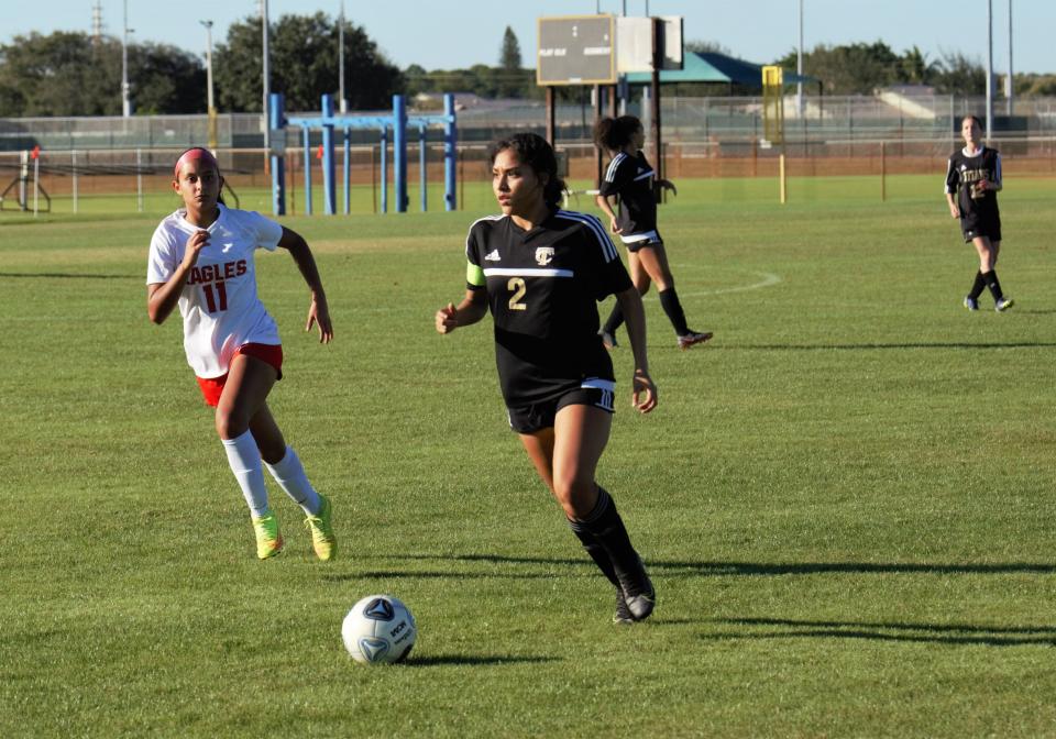 Treasure Coast's Brenda Vargas races down the pitch with Centennial's Rocio Espinosa tracking back to defend during a high school soccer match in Port St. Lucie on Tuesday, Jan. 18, 2022. Vargas scored a goal in the first half and added an assist in the second half as the Titans won the match 3-1.