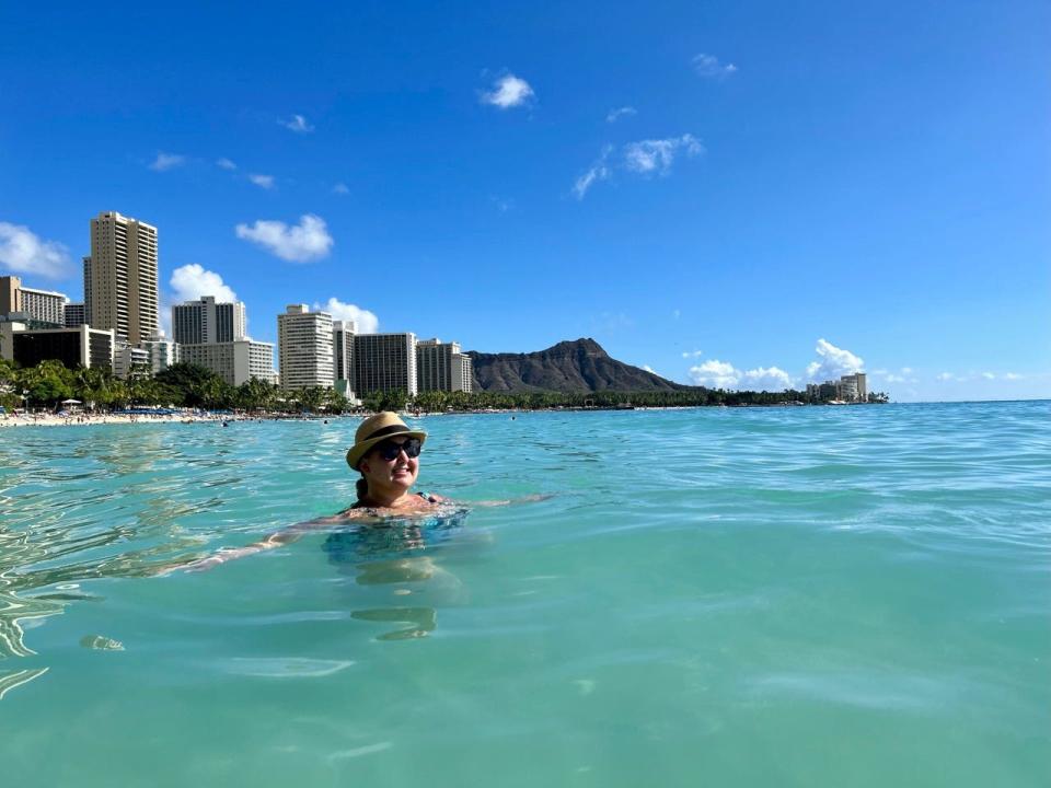 Author Carly Caramanna in water near Royal Hawaiian Pink Hotel 