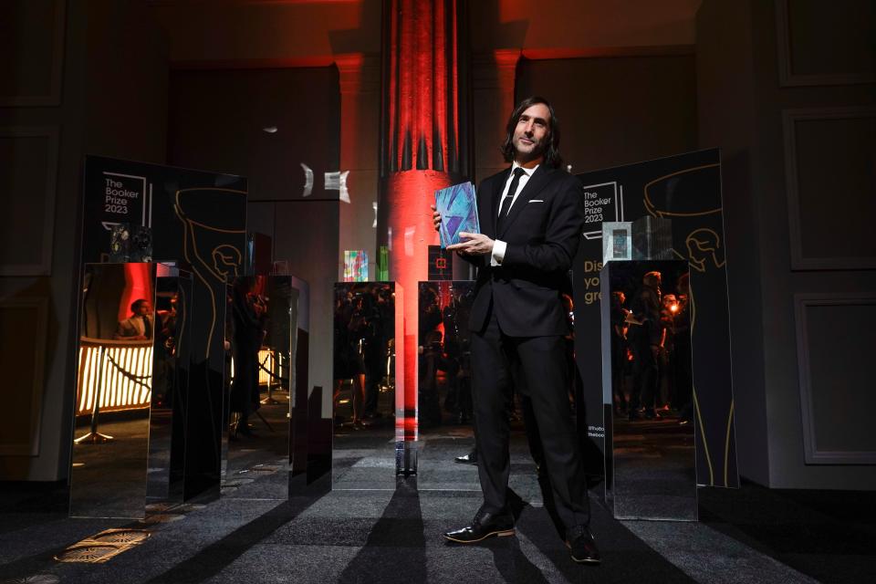 Paul Lynch poses with his book as he arrives at the Booker Prize award dinner in London on Nov. 26, 2023.