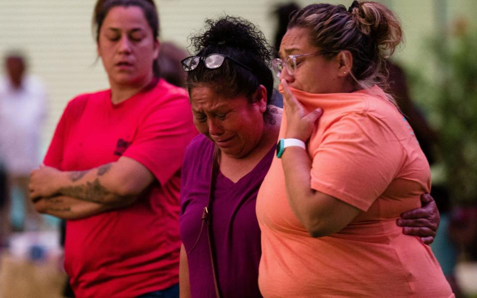 Family members await news of a missing relative after the school massacre - Shutterstock