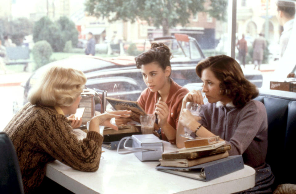 Three women sitting in a diner booth from the movie back to the future