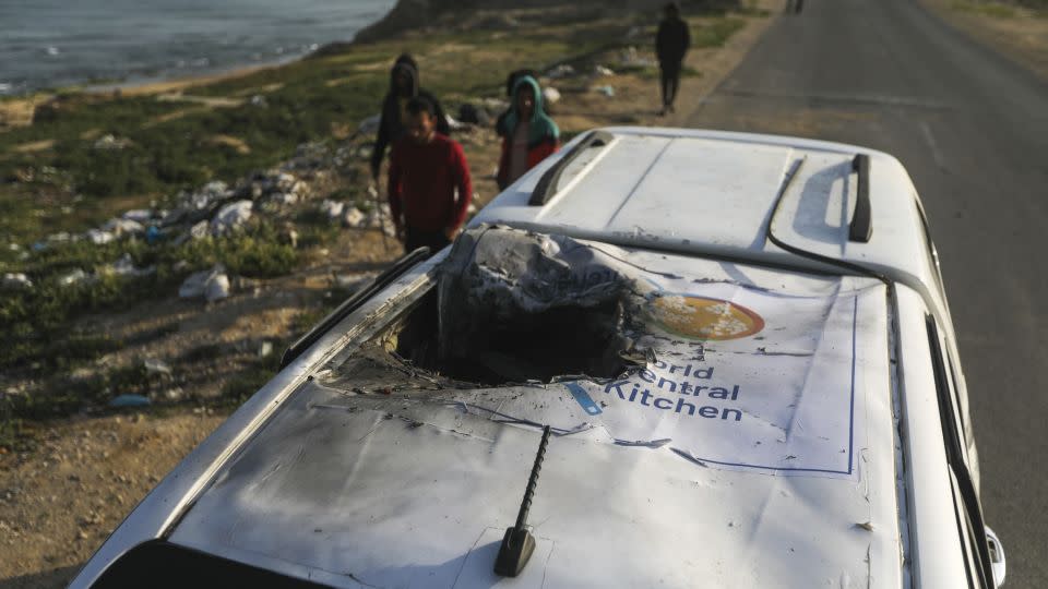 Palestinians inspect a vehicle with the logo of the World Central Kitchen wrecked by an Israeli airstrike in Deir al Balah, Gaza Strip, on April 2. - Ismael Abu Dayyah/AP