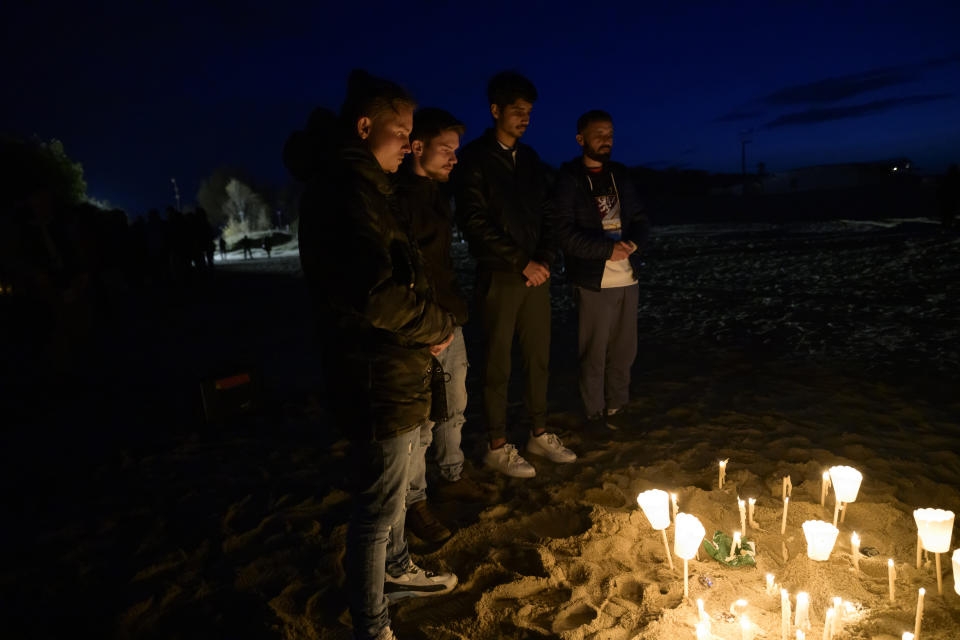 Survivors and relatives of the victims pray, Monday, Feb. 26, 2024, at the site where a migrant boat capsized in the early morning of Sunday, Feb. 26, 2023, at a short distance from the shore in Steccato di Cutro, in the Italian southern tip, killing at least 94 people. Survivors and family members of the victims gathered at the same time on the day of the disaster for a commemoration on the first anniversary. (AP Photo/Valeria Ferraro)