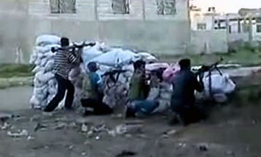 An image grab taken from a video uploaded on YouTube allegedly shows members of the Free Syrian Army (FSA) fighting against government forces in the village of Taldou, near the town of Houla in Syria's Homs province. Russia reported finding agreement with the United States on Syria and voiced optimism that crucial Geneva talks Saturday could bring a shift toward peace after 16 months of bloodshed