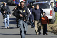 FILE - Parents leave a staging area after being reunited with their children following a shooting at the Sandy Hook Elementary School in Newtown, Conn. where authorities say a gunman opened fire, leaving 27 people dead, including 20 children, Friday, Dec. 14, 2012. After a weekend of gun violence in America, Saturday, May 14, 2022, when shootings killed and wounded people grocery shopping, going to church and simply living their lives, the nation marked a milestone of 1 million deaths from COVID-19. The number, once unthinkable, is now a pedestrian reality in the United States, just as is the reality of the continuing epidemic of gun violence that kills tens of thousands of people a year. (AP Photo/Jessica Hill, File)