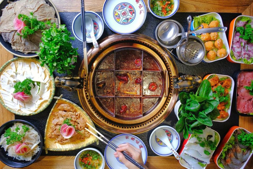 Hotpot with condiments surrounding the pot