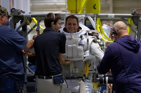 NASA Commercial Crew Astronaut Josh Cassada is helped into his space suit at NASA's Neutral Buoyancy Laboratory (NBL) training facility near the Johnson Space Center in Houston