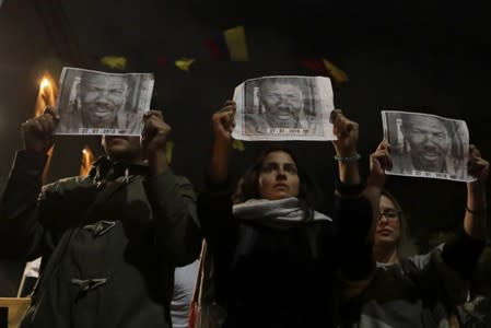 People hold posters with the photograph of Temistocles Machado, Colombian social leader killed, during protest against the killing of social activists, in Bogota