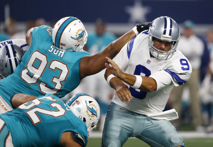 Tony Romo attempts to avoid a greeting from Ndamukong Suh. (AP) 