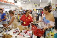 <p>City Mill hardware store sales associate Lisa Lavilla, left, talks to customer Ginger McCorriston about hurricane supplies, Wednesday, Aug. 22, 2018, in Honolulu. McCorriston was trying to find duck tape and batteries before they run out. (Photo: Marco Garcia/AP) </p>