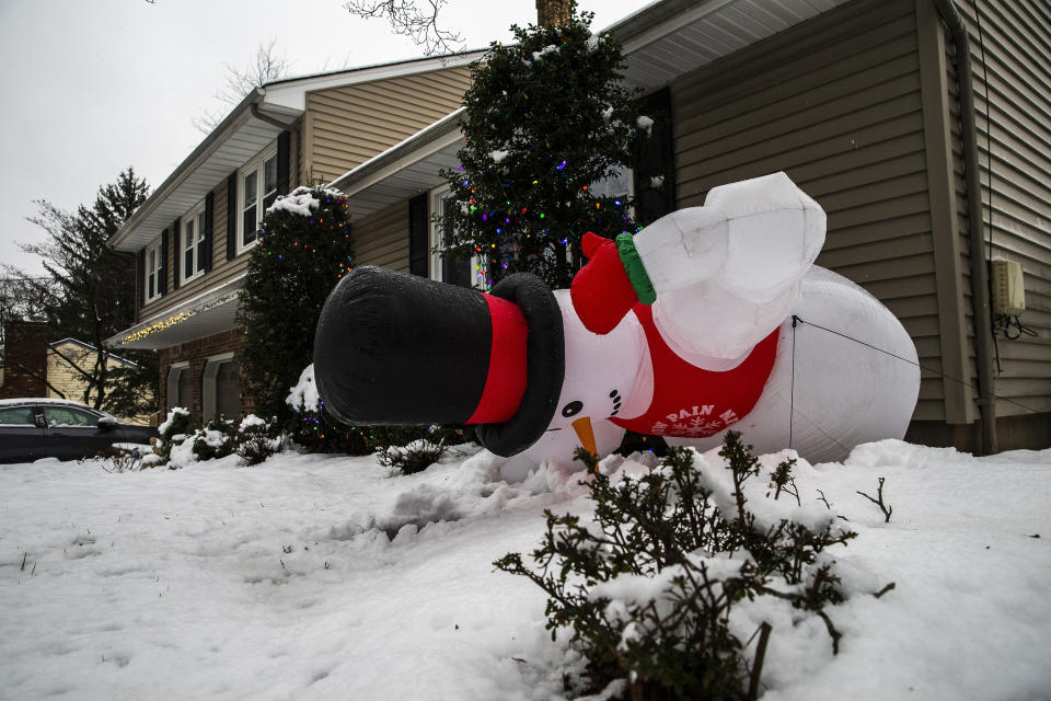An inflatable snowman falls down during a winter storm in Orangeburg, N.Y. Sunday, Jan. 7, 2024. (AP Photo/Eduardo Munoz Alvarez)