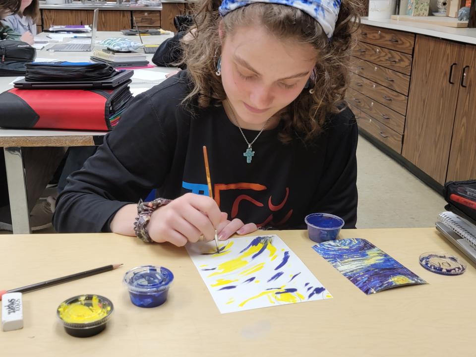 Jefferson High School student Veronica Fitzgerald uses acrylic paint to create a panel for a mixed media art project.