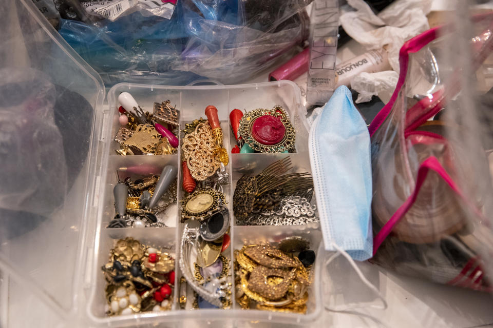 A face mask lies amid jewellery on the dressing room where flamenco Dancer Marina Perez prepares to take part in the Torres Bermejas "tablao," or live flamenco venue, in Madrid, Spain, Saturday, Sept. 26, 2020. The passion and drama of live flamenco shows are back on stage in Madrid. But now the performers are behind Perspex screens and keeping their distance from the audience. The Torres Bermejas “tablao,” or live flamenco venue, has reopened its doors to customers after seven months closed due to the COVID-19 pandemic. (AP Photo/Manu Fernandez)