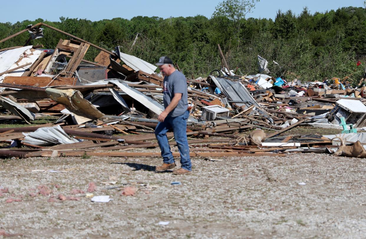 Carl Kelley walks past tornado damage on his property Tuesday outside Barnsdall.