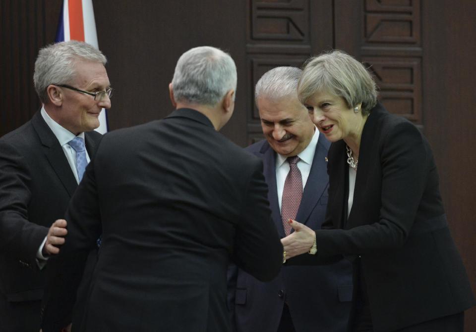 In this Saturday, Jan. 28, 2017 photo, British Prime Minister Theresa May, right, talks to Temel Kotil, back on camera, CEO of Turkish Aerospace industries, as Turkey's Prime Minister Binali Yildirim, 2nd right and Ian Graham King, left, CEO of BAE Systems look on after signing an agreement in Ankara,Turkey. Turkey and Britain signed the 100 million British pounds (nearly $125.5 million) deal to jointly build fighter jets during May's visit to Ankara on Saturday, even as the British leader called on Turkey's government to uphold democracy and abide by human rights standards. (AP Photo)