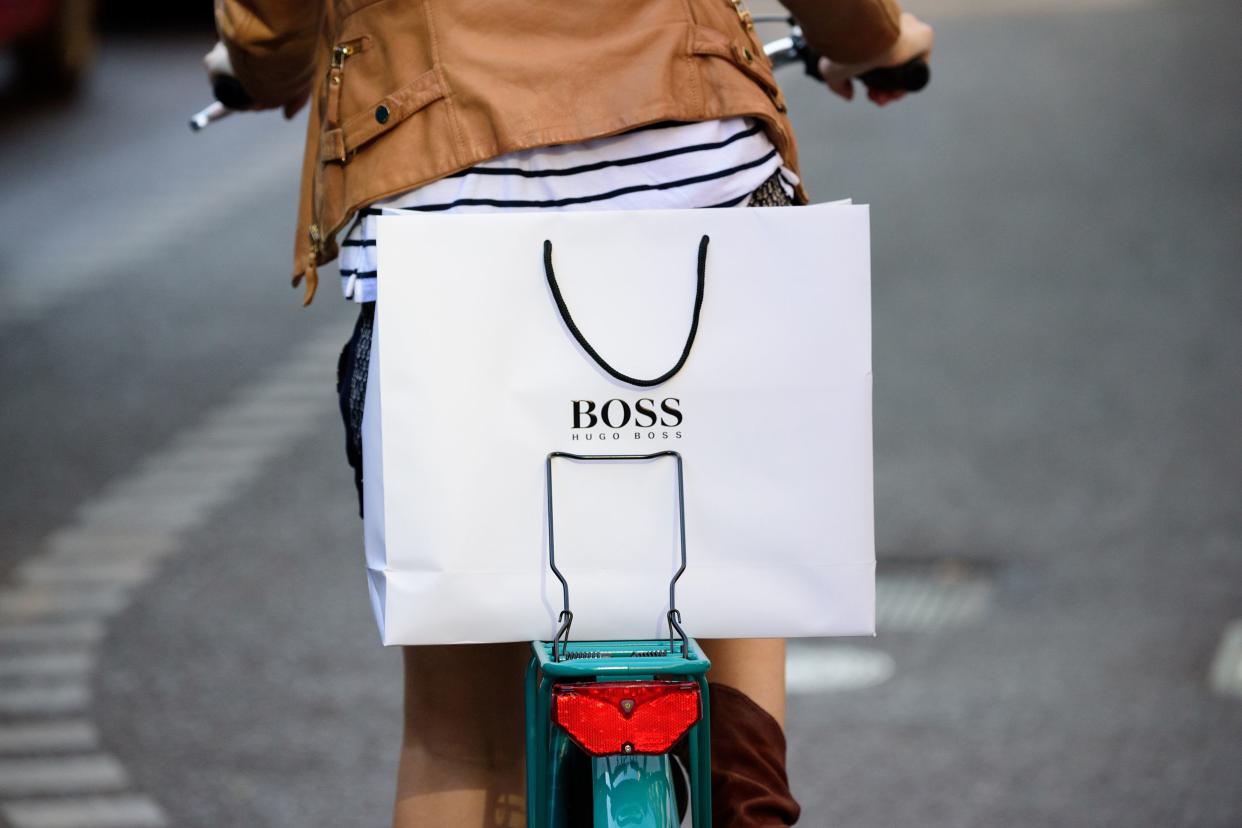 rear view of shopping woman on bike in bike lane with Hugo Boss bag