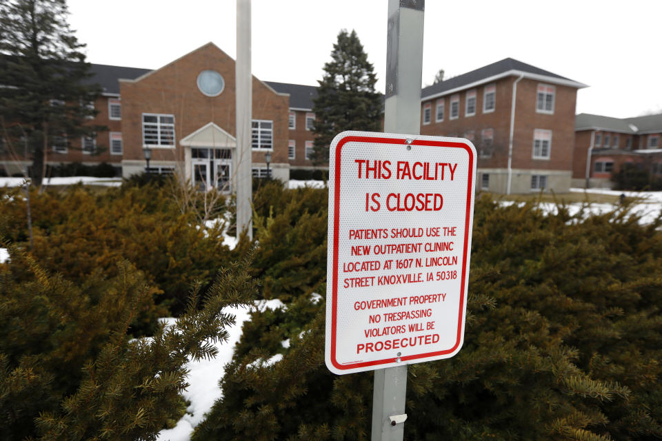 FILE - In this March 12, 2019 file photo, a facility closed sign hangs in front of the main building on the Veterans Affairs campus in Knoxville, Iowa. After watching for more than a decade as a once busy Veterans Affairs campus deteriorated into a sprawling ghost town, leaders of a small Iowa city announced plans to take control of the property and likely demolish most of the structures. City and county officials signed documents Wednesday, Jan. 15, 2020, taking ownership of the 153-acre property. (AP Photo/Charlie Neibergall, File)