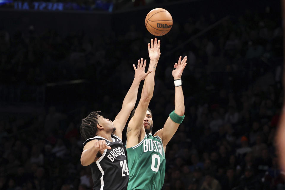 Boston Celtics forward Jayson Tatum (0) shoots against Brooklyn Nets guard Cam Thomas (24) during the first half of an NBA basketball game, Sunday, Dec. 4, 2022, in New York. (AP Photo/Jessie Alcheh)