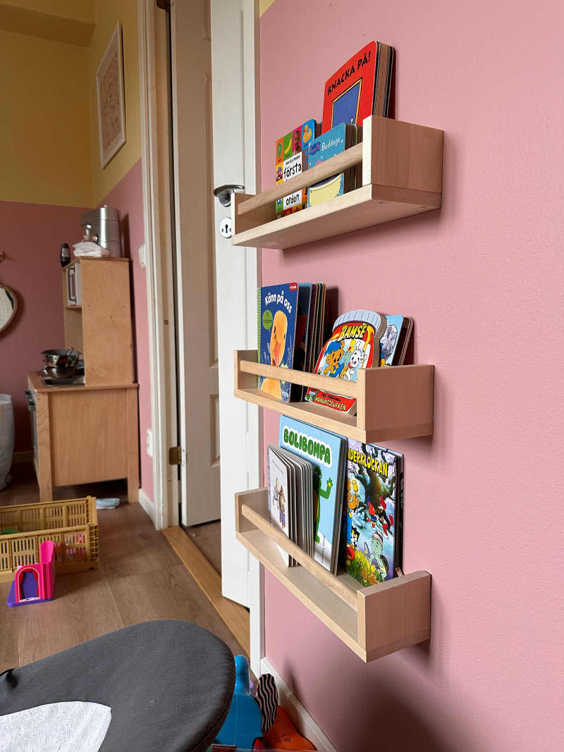 Children's books stored on a floating shelf.