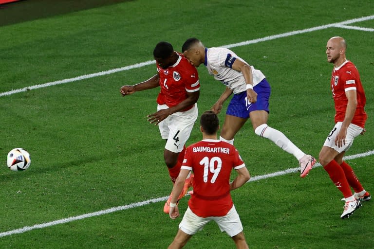 Le capitaine de l'équipe de France Kylian Mbappe (en blanc) dans un choc nez contre épaule avec le défenseur autrichien Kevin Danso, lors de la victoire des Bleus 1-0 dans leur match de l'Euro-2024, lundi 17 juin dans la Dusseldorf Arena de Dusseldorf. (KENZO TRIBOUILLARD)