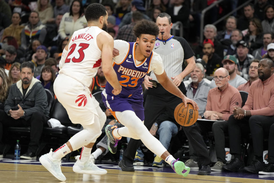 Phoenix Suns forward Cameron Johnson, right, drives against Toronto Raptors guard Fred VanVleet, left, during the second half of an NBA basketball game, Monday, Jan. 30, 2023, in Phoenix. (AP Photo/Rick Scuteri)