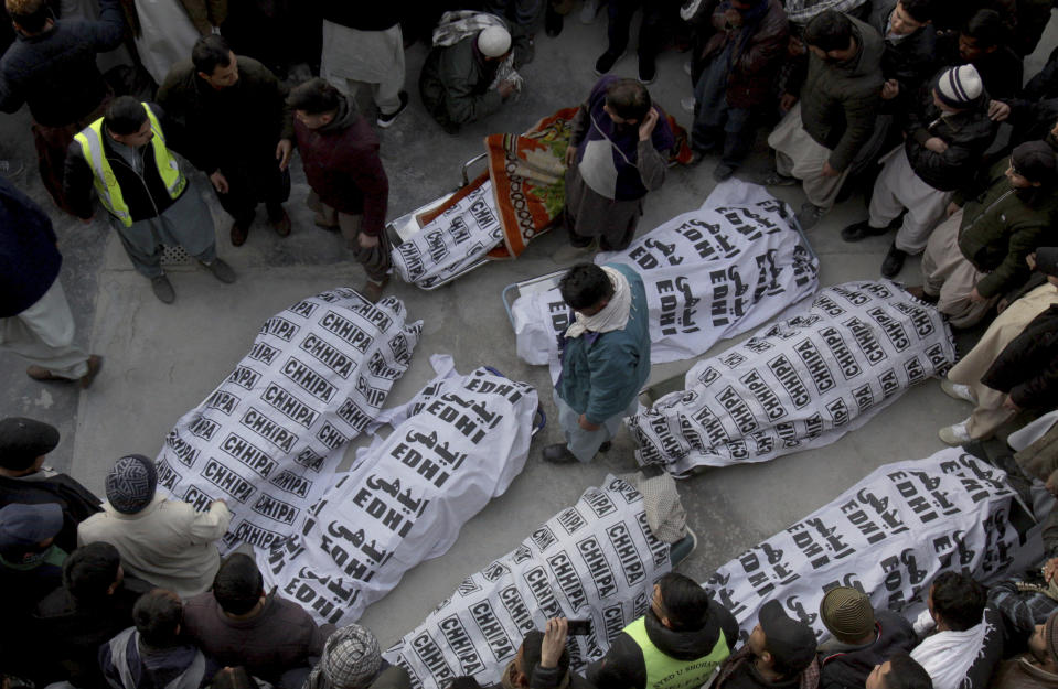 People from the Shiite Hazara community gather around the bodies of coal mine workers who were killed by unknown gunmen near the Machh coal field, in Quetta, Pakistan, Sunday, Jan. 3, 2021. Gunmen opened fire on a group of minority Shiite Hazara coal miners after abducting them, killing 11 in southwestern Baluchistan province early Sunday, a Pakistani official said. (AP Photo/Arshad Butt)