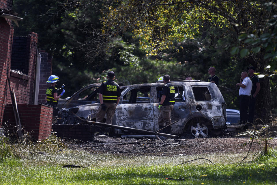 A firefighter inspects a burnt car from a house fire in Newnan, Ga. on Monday, June 17, 2024. (Ziyu Julian Zhu/Atlanta Journal-Constitution via AP)