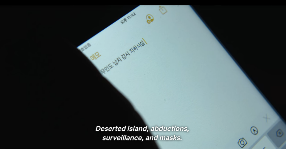a phone with the words "deserted island, abductions, surveillance, and masks"