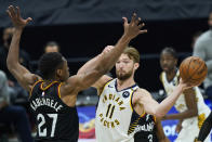 Indiana Pacers' Domantas Sabonis (11) passes around Cleveland Cavaliers' Mfiondu Kabengele (27) in the second half of an NBA basketball game, Monday, May 10, 2021, in Cleveland. (AP Photo/Tony Dejak)