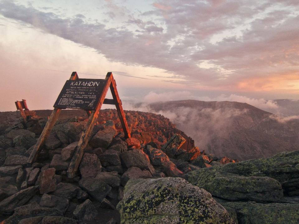 the summit sign on maines mount katahdin seen at sunrise