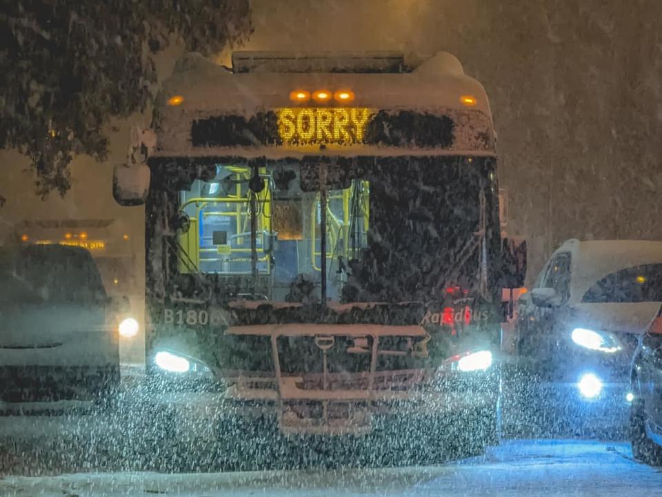 A bus is pictured near the 22nd Street SkyTrain Station as snow slams Metro Vancouver on Tuesday, Nov 29. TransLink says numerous collisions in the Lower Mainland overnight contributed to delayed bus service Wednesday morning. (Submitted by Sowjanya Kiran  - image credit)