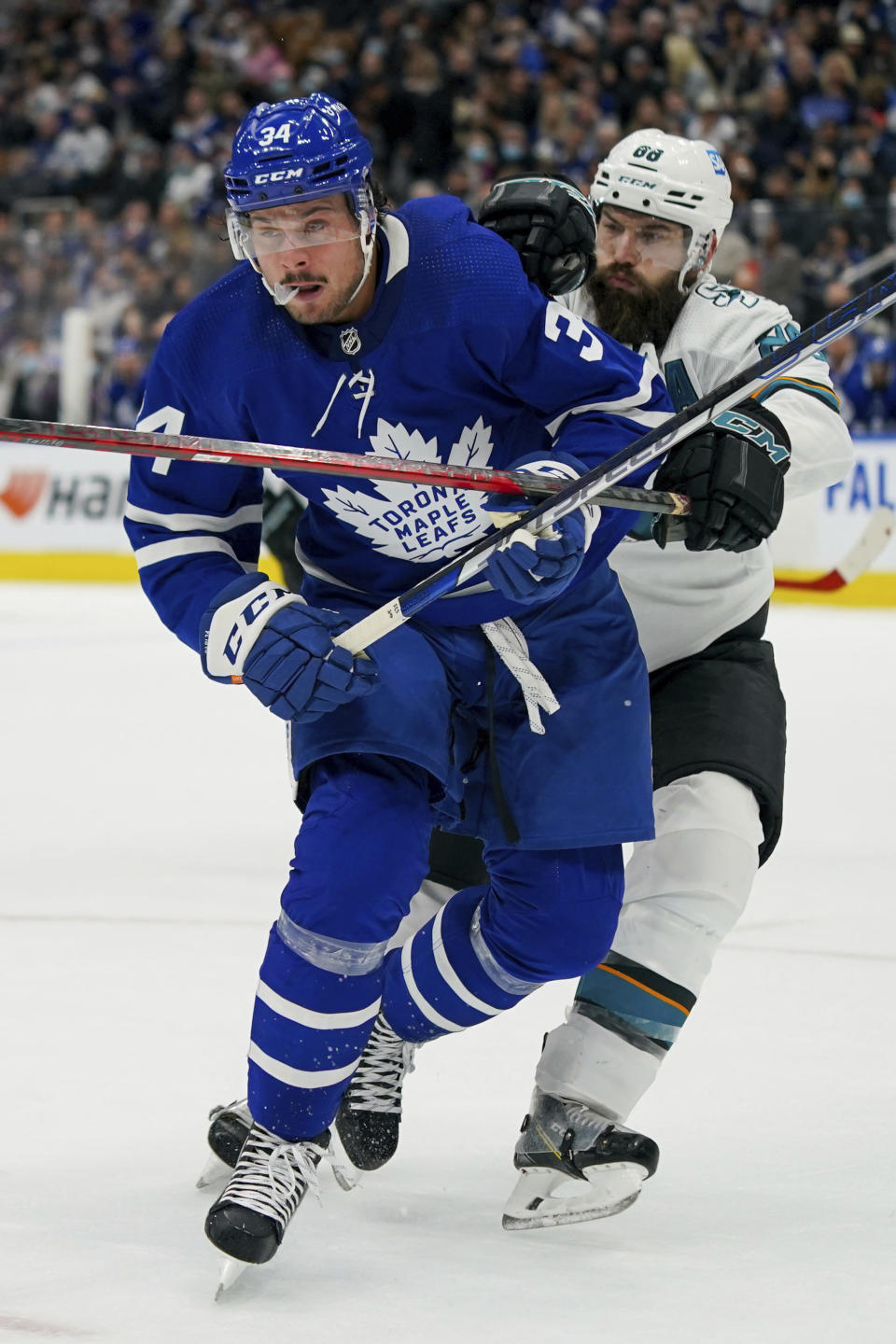 Toronto Maple Leafs forward Auston Matthews (34) and San Jose Sharks defenseman Brent Burns (88) viefor position while going for the puck during the second period of an NHL hockey game Friday, Oct. 22, 2021, in Toronto. (Evan Buhler/The Canadian Press via AP)