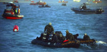 In this Tuesday, April 22, 2014, searchers and divers look for people believed to have been trapped in the sunken ferry Sewol in the water off the southern coast near Jindo, south of Seoul, South Korea. One by one, coast guard officers carried the newly arrived bodies covered in white sheets from a boat to a tent on the dock of this island, the first step in identifying a sharply rising number of corpses from the South Korean ferry that sank nearly a week ago. (AP Photo/Korea Pool) KOREA OUT