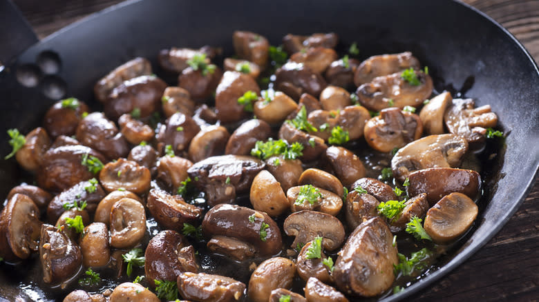 Mushrooms with herbs sauteing in a pan