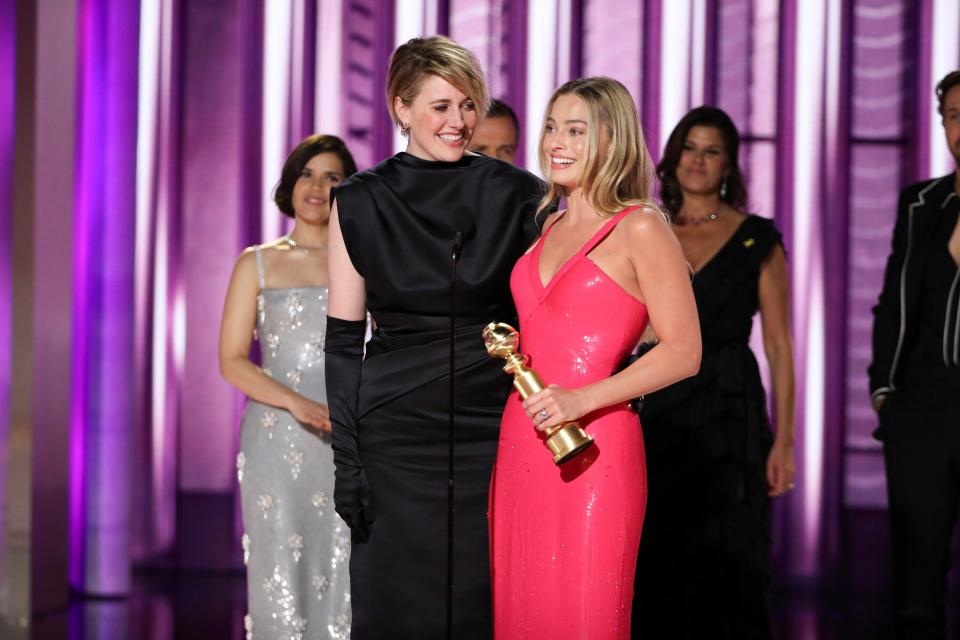 Director and co-writer Greta Gerwig, left, and actor Margot Robbie accepting the Golden Globe for best cinematic and box office achievement for the film "Barbie."