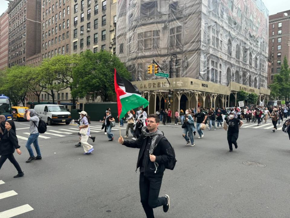A man running with a Palestinian flag during the march from Hunter College to the Met Gala. Jack Morphet/NY Post