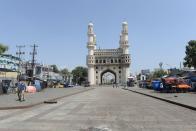 Police personnel stand guard on a deserted road in front of historical Charminar monument during a one-day nationwide Janata (civil) curfew imposed as a preventive measure against the COVID-19 coronavirus, in Hyderabad on March 22, 2020. - Nearly one billion people around the world were confined to their homes, as the coronavirus death toll crossed 13,000 and factories were shut in worst-hit Italy after another single-day fatalities record. (Photo by NOAH SEELAM / AFP) (Photo by NOAH SEELAM/AFP via Getty Images)