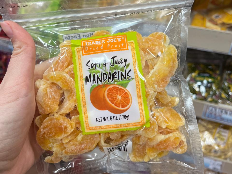 hand holding up a bag of dried mandarins att trader joes