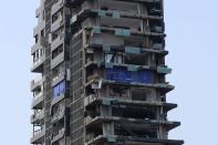 A man is seen on the balcony of a destroyed building, following a massive explosion, in Beirut