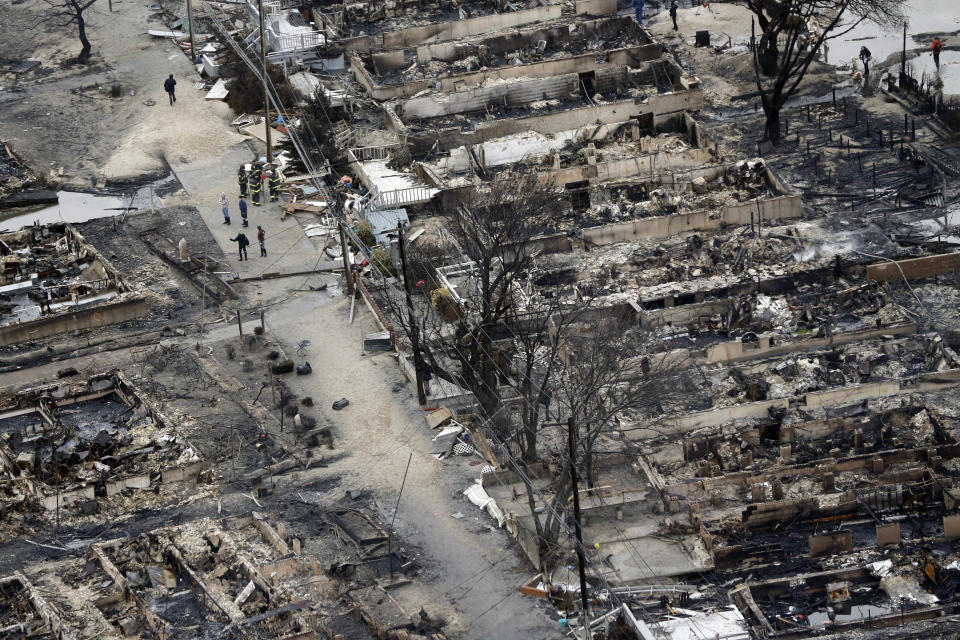 This aerial photo shows burned-out homes in the Breezy Point section of the Queens borough New York after a fire on Tuesday, Oct. 30, 2012. The tiny beachfront neighborhood told to evacuate before Sandy hit New York burned down as it was inundated by floodwaters, transforming a quaint corner of the Rockaways into a smoke-filled debris field. (AP Photo/Mike Groll)