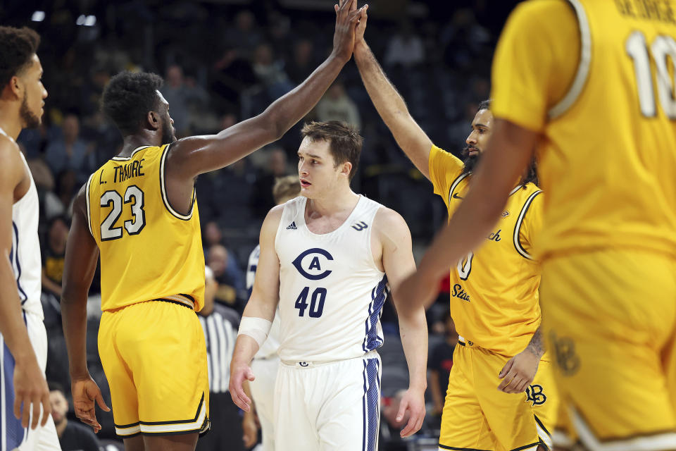 Long Beach State's Lassina Traore (23) and Marcus Tsohonis (0) high-five over UC Davis' Elijah Pepper (40) during the second half of an NCAA college basketball game in the championship of the Big West Conference men's tournament Saturday, March 16, 2024, in Henderson, Nev. (AP Photo/Ronda Churchill)