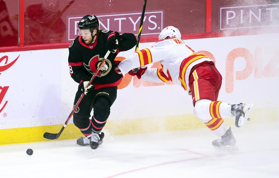 Ottawa Senators right wing Connor Brown (28) skates the puck away from Calgary Flames defenseman Juuso Valimaki (6) during third period NHL hockey action in Ottawa on Monday, March 1, 2021. (Sean Kilpatrick/The Canadian Press via AP)